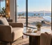 Illustrative airport lounge with comfortable seating, a suitcase and an aircraft beyond the windows